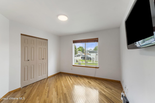3025 N Sand Trap Way, Post Falls, ID 83854 - unfurnished bedroom with light wood finished floors, baseboards, and a closet