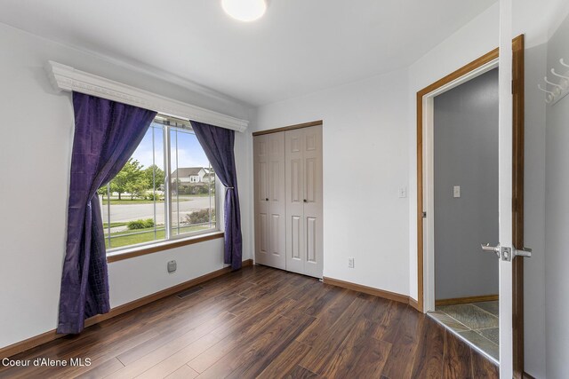 3025 N Sand Trap Way, Post Falls, ID 83854 - unfurnished bedroom featuring dark wood-style flooring, baseboards, and a closet