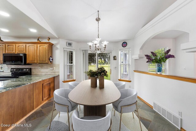 3025 N Sand Trap Way, Post Falls, ID 83854 - dining space with a chandelier, stone tile floors, recessed lighting, and baseboards