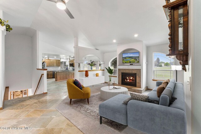 3025 N Sand Trap Way, Post Falls, ID 83854 - living room featuring ceiling fan, stone tile flooring, a tiled fireplace, recessed lighting, and vaulted ceiling