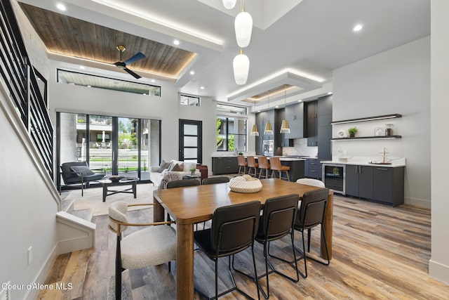 2888 W Lumber Ln, Coeur Dalene, ID 83814 - dining room featuring beverage cooler, baseboards, light wood-style flooring, recessed lighting, and bar