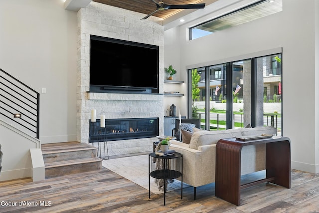 2888 W Lumber Ln, Coeur Dalene, ID 83814 - living room with stairs, baseboards, a fireplace, wood finished floors, and a towering ceiling