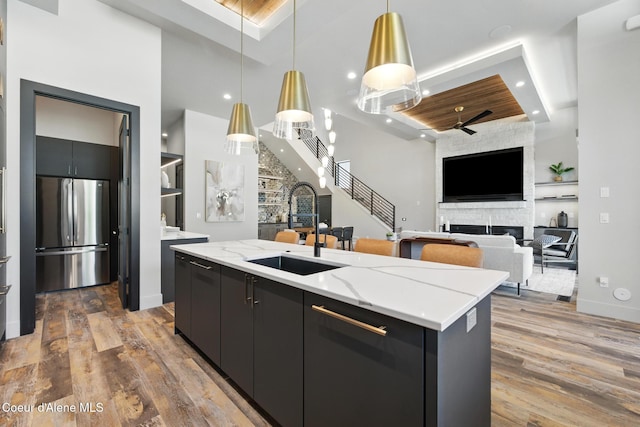 2888 W Lumber Ln, Coeur Dalene, ID 83814 - kitchen featuring freestanding refrigerator, a sink, open floor plan, dark cabinets, and a center island with sink