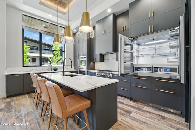 2888 W Lumber Ln, Coeur Dalene, ID 83814 - kitchen featuring a sink, light wood-style floors, stainless steel gas stovetop, a raised ceiling, and modern cabinets