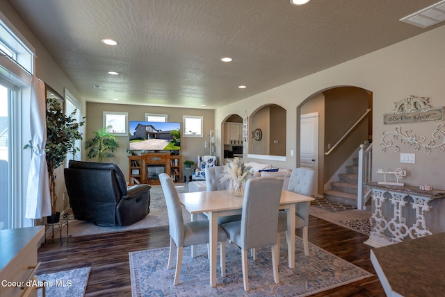 3423 E Hope Ave, Post Falls, ID 83854 - dining room with a glass covered fireplace, stairway, recessed lighting, dark wood-type flooring, and a textured ceiling