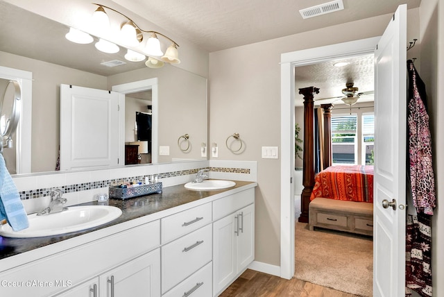 3423 E Hope Ave, Post Falls, ID 83854 - full bath featuring double vanity, connected bathroom, wood finished floors, baseboards, and decorative backsplash