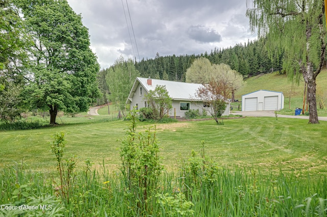59A Creek Side Dr, Wallace, ID 83873 - view of grassy yard featuring an outdoor structure, a detached garage, and a view of trees