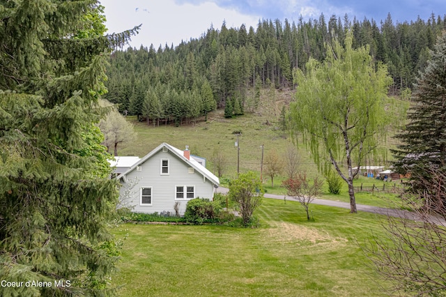 59A Creek Side Dr, Wallace, ID 83873 - view of side of home with a forest view, a lawn, and a chimney
