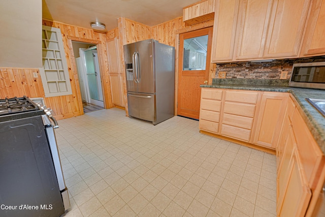 59A Creek Side Dr, Wallace, ID 83873 - kitchen featuring appliances with stainless steel finishes, wooden walls, decorative backsplash, dark countertops, and light brown cabinets