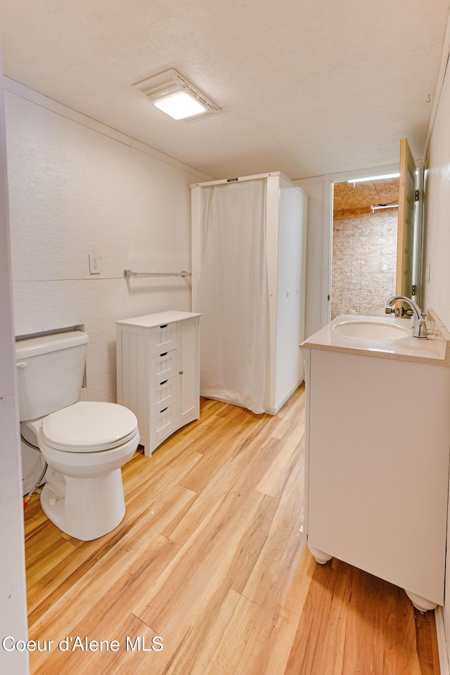 59A Creek Side Dr, Wallace, ID 83873 - full bathroom featuring vanity, toilet, wood finished floors, and a shower with shower curtain