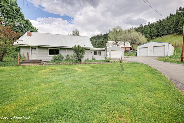 59A Creek Side Dr, Wallace, ID 83873 - view of front of house featuring a garage, a front lawn, an outbuilding, a metal roof, and a chimney
