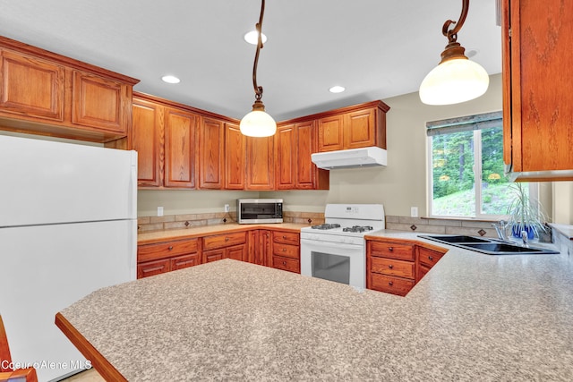 5340 W Hull Loop, Coeur Dalene, ID 83814 - kitchen with white appliances, under cabinet range hood, a sink, recessed lighting, and a peninsula