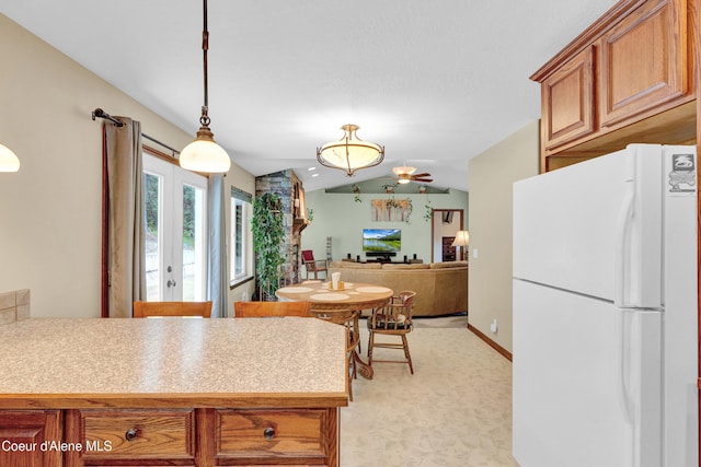 5340 W Hull Loop, Coeur Dalene, ID 83814 - kitchen with freestanding refrigerator, vaulted ceiling, brown cabinets, light countertops, and decorative light fixtures