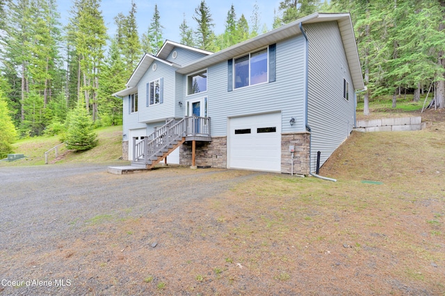 5340 W Hull Loop, Coeur Dalene, ID 83814 - raised ranch featuring a garage, driveway, stone siding, and stairs