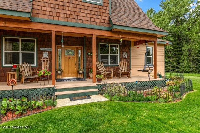 88 Fenway Dr, Sagle, ID 83860 - entrance to property featuring covered porch, a yard, and roof with shingles