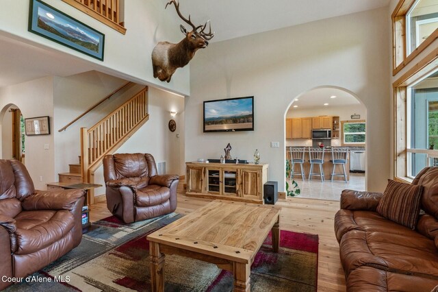 88 Fenway Dr, Sagle, ID 83860 - living area with arched walkways, a towering ceiling, light wood-type flooring, and stairway