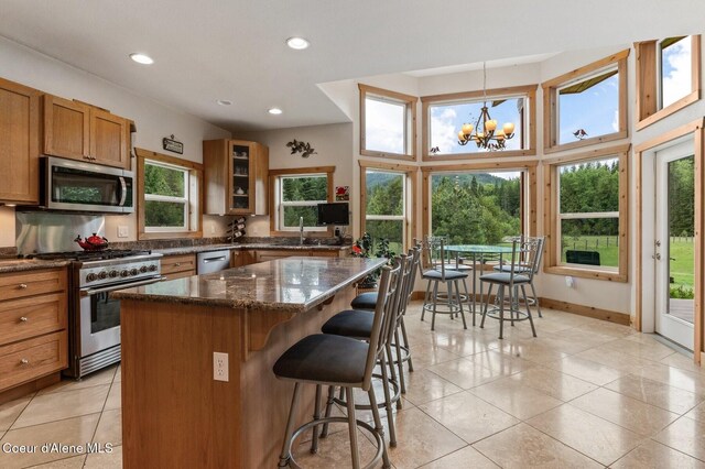 88 Fenway Dr, Sagle, ID 83860 - kitchen with appliances with stainless steel finishes, brown cabinetry, a sink, a kitchen breakfast bar, and a kitchen island