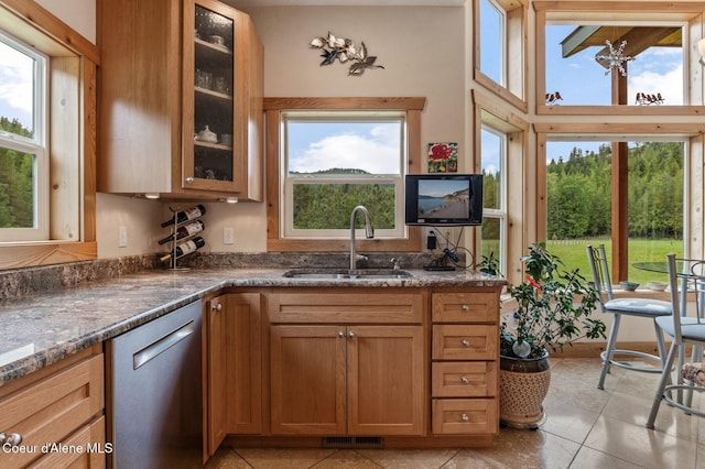 88 Fenway Dr, Sagle, ID 83860 - kitchen with stainless steel dishwasher, a sink, dark stone countertops, and glass insert cabinets