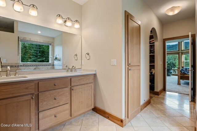 88 Fenway Dr, Sagle, ID 83860 - bathroom with tile patterned floors, double vanity, plenty of natural light, and baseboards