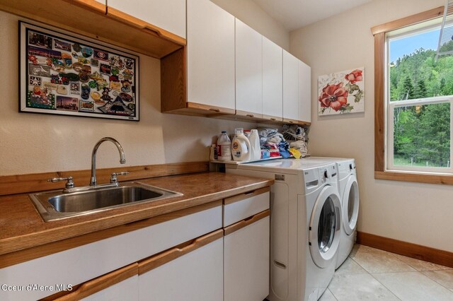 88 Fenway Dr, Sagle, ID 83860 - laundry area with cabinet space, washing machine and dryer, light tile patterned floors, and baseboards