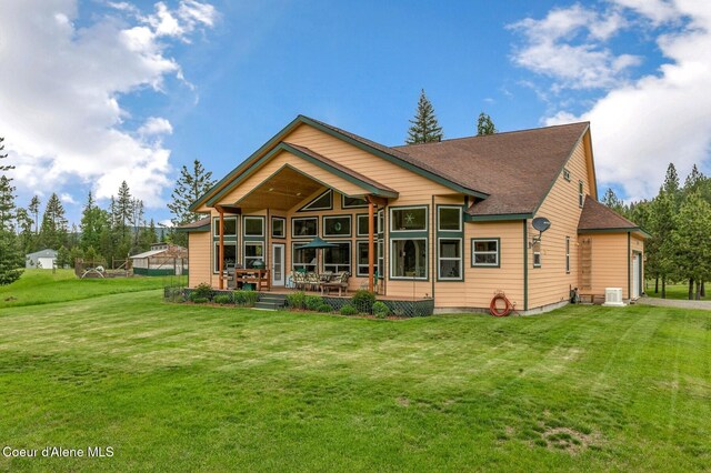 88 Fenway Dr, Sagle, ID 83860 - back of property with a lawn, central AC unit, roof with shingles, and driveway