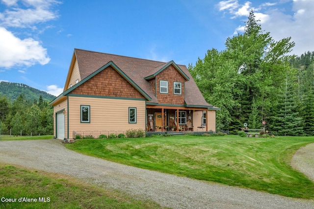 88 Fenway Dr, Sagle, ID 83860 - view of front of house with a garage, driveway, covered porch, a front lawn, and a mountain view