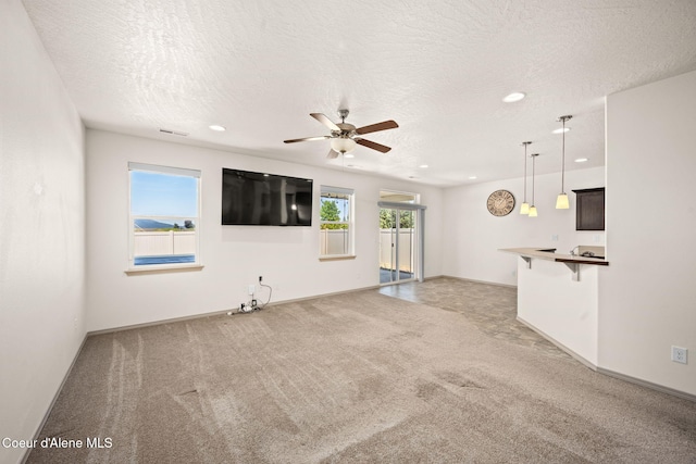4717 N Connery Loop, Post Falls, ID 83854 - unfurnished living room with light colored carpet, a ceiling fan, recessed lighting, and a textured ceiling