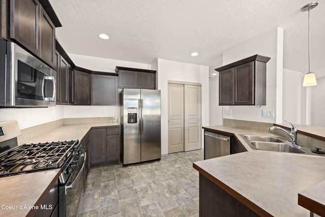 4717 N Connery Loop, Post Falls, ID 83854 - kitchen featuring appliances with stainless steel finishes, dark brown cabinetry, a textured ceiling, pendant lighting, and stone finish flooring