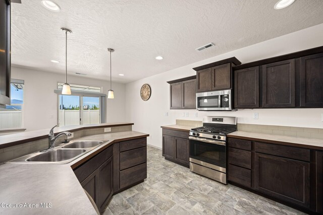 4717 N Connery Loop, Post Falls, ID 83854 - kitchen with stainless steel appliances, dark brown cabinets, a textured ceiling, recessed lighting, and light countertops