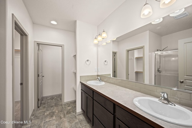 4717 N Connery Loop, Post Falls, ID 83854 - bathroom with a spacious closet, a shower stall, double vanity, stone finish flooring, and tasteful backsplash