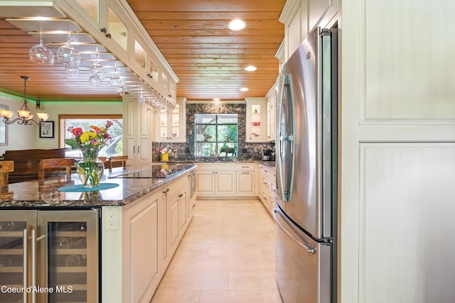 471 Kaniksu Shores Rd, Sandpoint, ID 83864 - kitchen with freestanding refrigerator, wood ceiling, beverage cooler, black electric stovetop, and glass insert cabinets