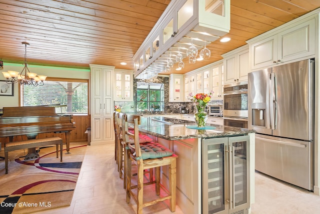 471 Kaniksu Shores Rd, Sandpoint, ID 83864 - kitchen with wood ceiling, appliances with stainless steel finishes, beverage cooler, a chandelier, and a center island