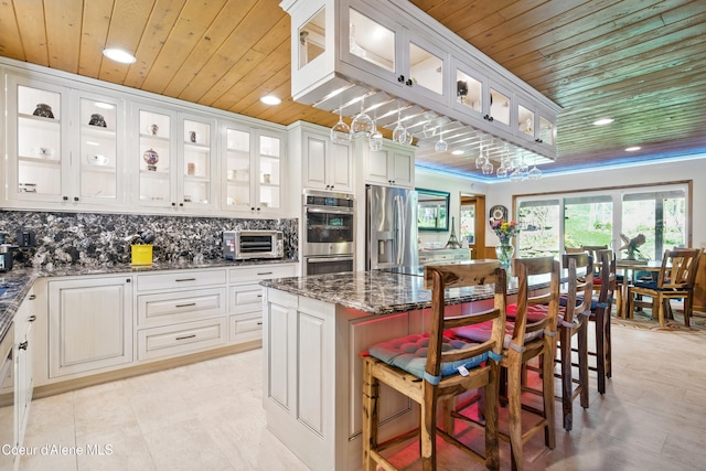471 Kaniksu Shores Rd, Sandpoint, ID 83864 - kitchen featuring wooden ceiling, stainless steel appliances, recessed lighting, dark stone countertops, and backsplash
