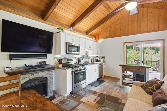 471 Kaniksu Shores Rd, Sandpoint, ID 83864 - kitchen with stainless steel appliances, wood ceiling with exposed beams, white cabinetry, a sink, and light wood-style floors
