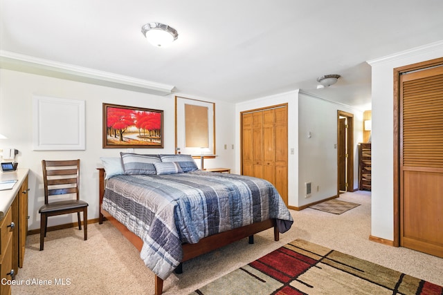 471 Kaniksu Shores Rd, Sandpoint, ID 83864 - bedroom with multiple closets, baseboards, light carpet, and crown molding