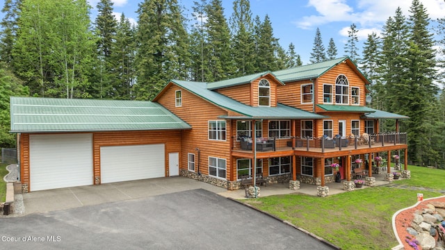 6918 E Garwood Rd, Hayden, ID 83835 - back of house with an attached garage, driveway, a yard, metal roof, and stone siding