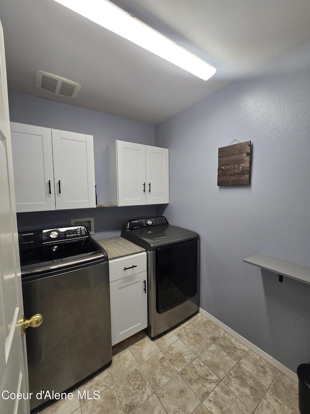 10566 N Seaside St, Hayden, ID 83835 - laundry area with cabinet space, washing machine and dryer, and baseboards