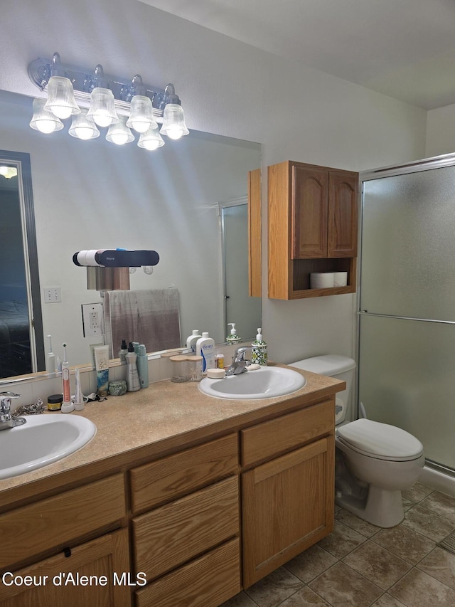 10566 N Seaside St, Hayden, ID 83835 - bathroom with a stall shower, double vanity, toilet, and tile patterned flooring