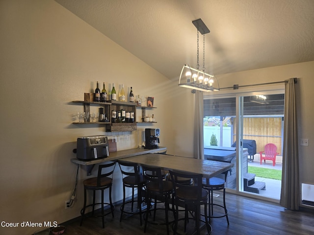 10566 N Seaside St, Hayden, ID 83835 - dining space with a bar, vaulted ceiling, and wood finished floors