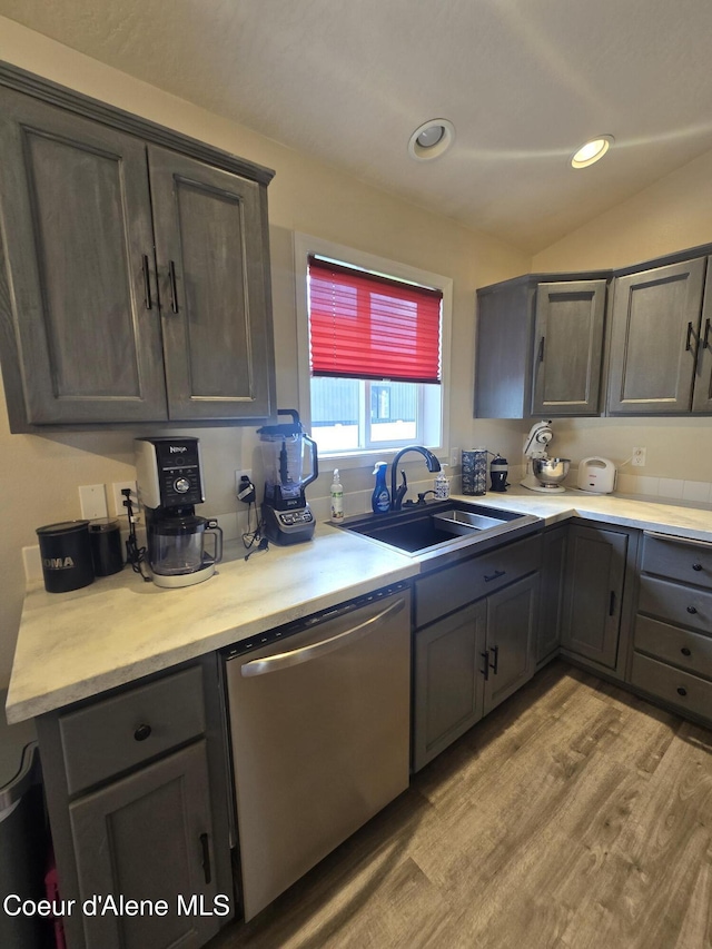 10566 N Seaside St, Hayden, ID 83835 - kitchen with dishwasher, a sink, light countertops, vaulted ceiling, and light wood finished floors