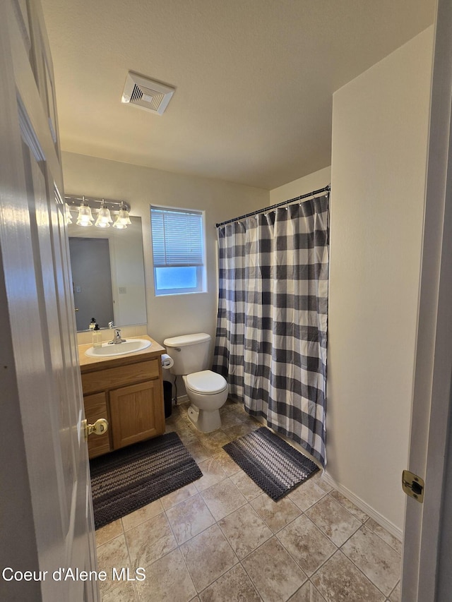 10566 N Seaside St, Hayden, ID 83835 - bathroom featuring toilet, vanity, a shower with curtain, and tile patterned floors