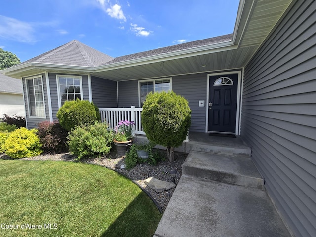 10566 N Seaside St, Hayden, ID 83835 - doorway to property featuring roof with shingles and a lawn
