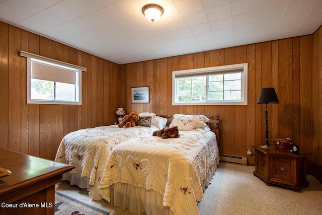97 S Granite Bay Rd, Nordman, ID 83848 - bedroom featuring multiple windows, a baseboard heating unit, light carpet, and wooden walls