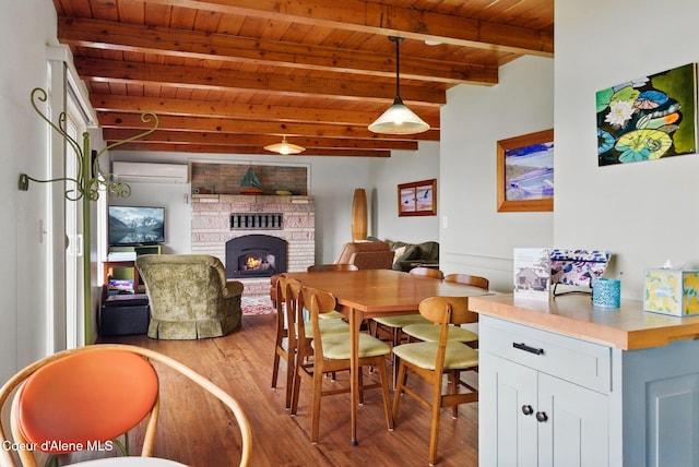 521 Aspen, Hope, ID 83836 - dining space with wooden ceiling with exposed beams, wood finished floors, a fireplace, and a wall unit AC