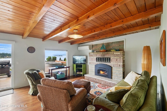 521 Aspen, Hope, ID 83836 - living room with a wall unit AC, wood ceiling with exposed beams, wood finished floors, and a brick fireplace