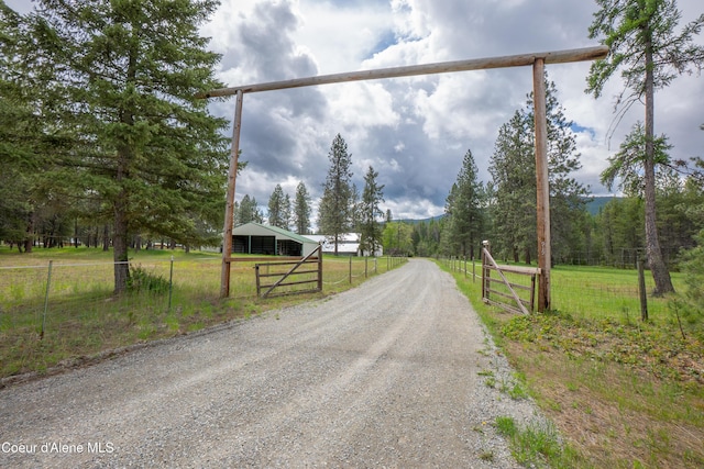 919 Silver Springs Rd, Moyie Springs, ID 83845 - view of dirt / gravel driveway with a rural view, a gated entry, and a pole building