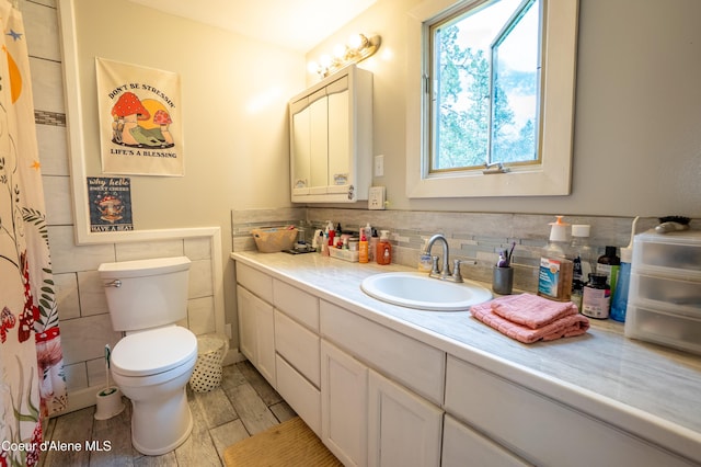 919 Silver Springs Rd, Moyie Springs, ID 83845 - bathroom with vanity, toilet, backsplash, and tile walls