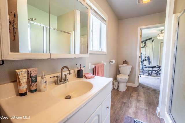 919 Silver Springs Rd, Moyie Springs, ID 83845 - bathroom with wood finished floors, an enclosed shower, vanity, toilet, and baseboards