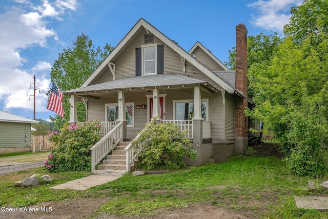 112 Washington St, Priest River, ID 83856 - bungalow-style house featuring a porch, a chimney, and a front yard