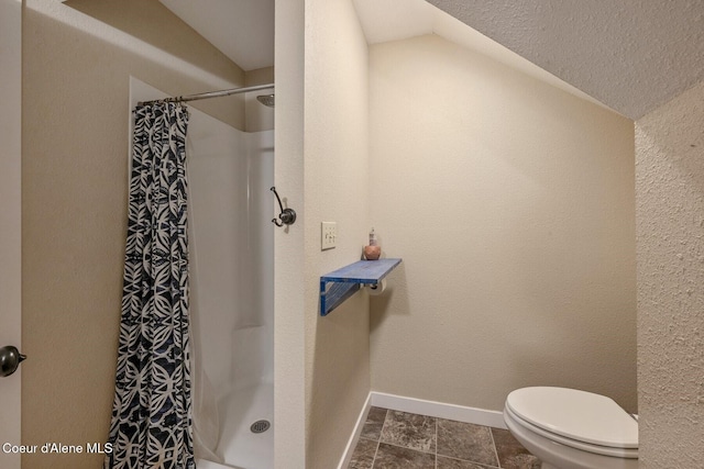 112 Washington St, Priest River, ID 83856 - bathroom with vaulted ceiling, a shower with shower curtain, toilet, and baseboards
